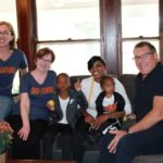Group photo with recipients of furniture donation.